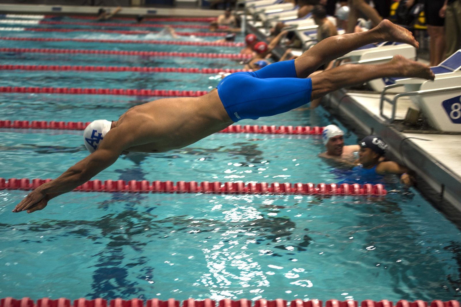 Competitive swimmers racing down the pool lanes during a championship swimming meet