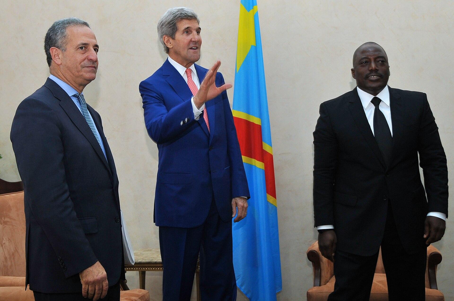 Joseph Kabila, then president of DR Congo, with U.S. Secretary of State John Kerry and envoy Russell Feingold in Kinshasa in May 2014, in front of the Congolese flag