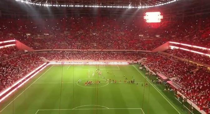 Un stade de football comble illuminé de nuit pendant un match, utilisé comme image d'illustration pour ce reportage