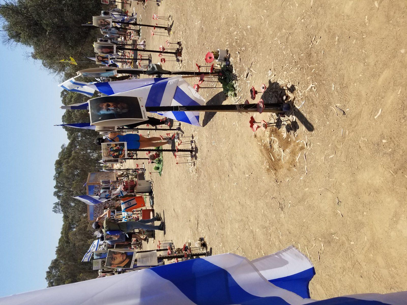 Site commémoratif de Re'im dans le sud d'Israël, en mémoire des attaques du 7 octobre 2023, avec des drapeaux et des pierres sous le ciel du désert